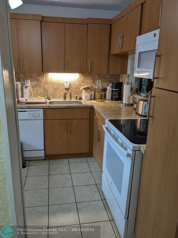 3130 Holiday Springs Boulevard, Unit 204 Margate, FL 33063 - Photo 10 of 32 a kitchen with a sink and cabinets