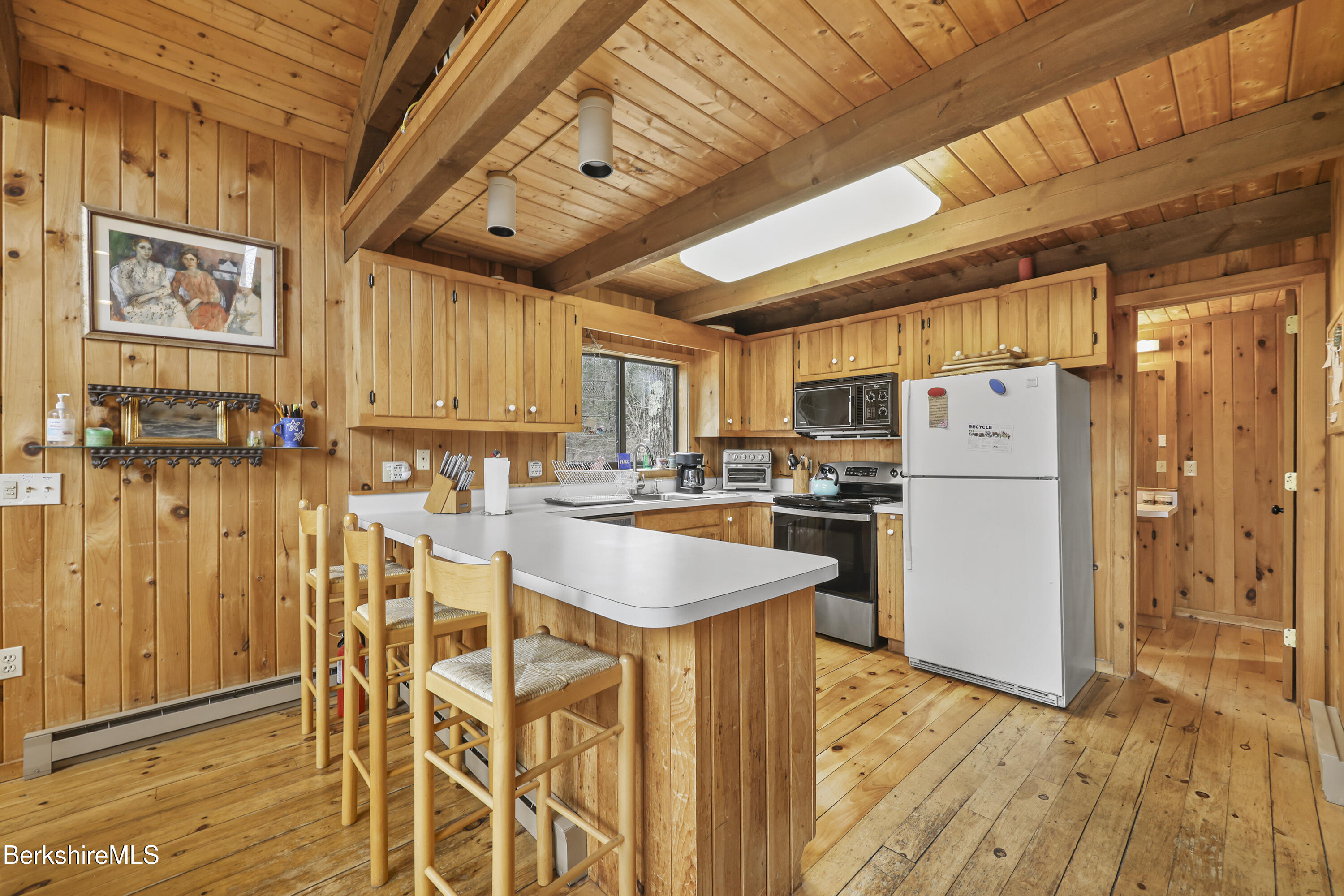 125 Town Hill Road Sandisfield, MA 01255 - Photo 12 of 42 a kitchen with granite countertop a refrigerator a stove a sink and white cabinets with wooden floor
