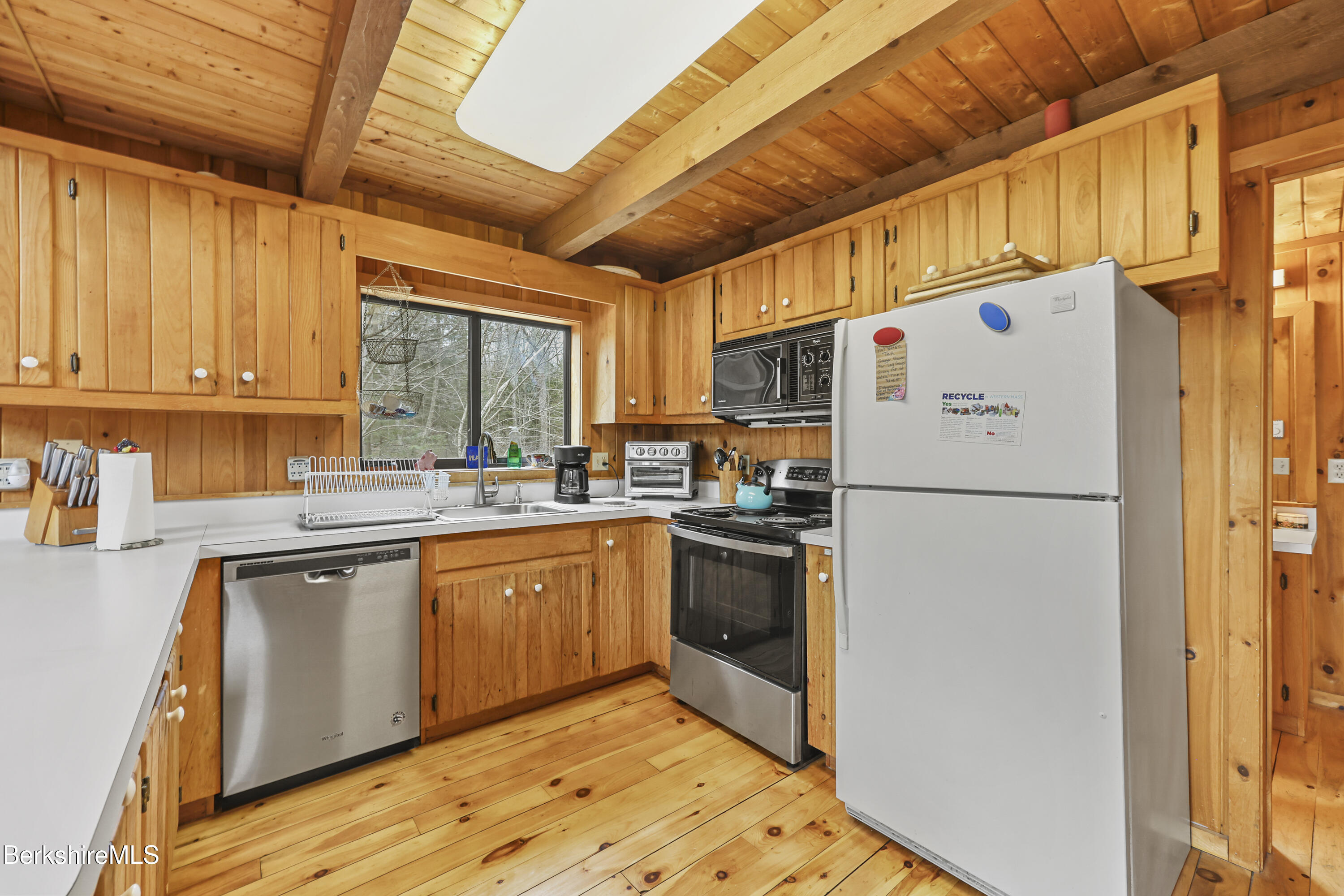 125 Town Hill Road Sandisfield, MA 01255 - Photo 10 of 42 a kitchen with stainless steel appliances granite countertop a refrigerator a sink dishwasher a stove with white cabinets and wooden floor