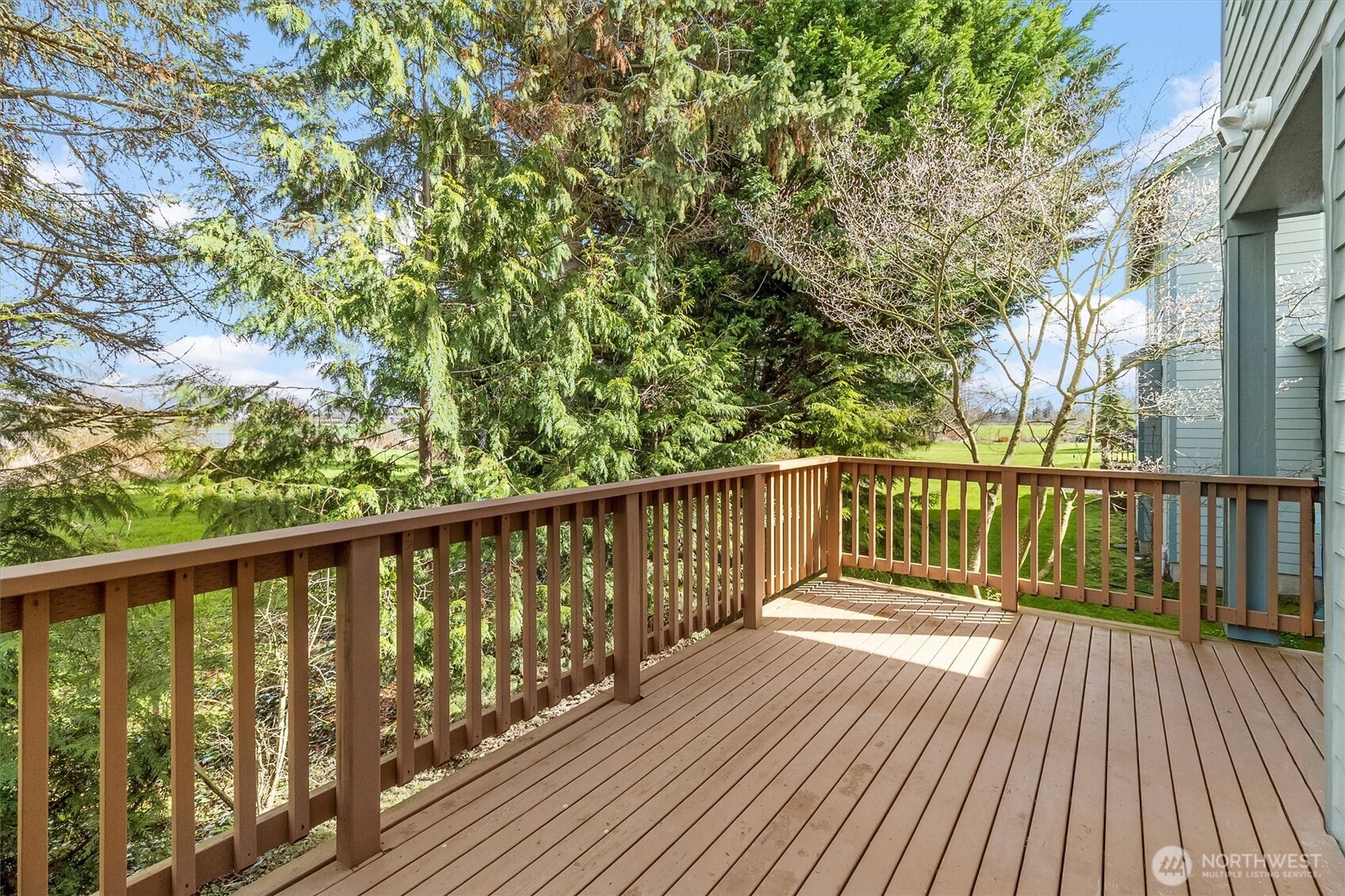 705 Finley Lane, Unit N2 La Conner, WA 98257 - Photo 29 of 38 a balcony with wooden floor and trees in the back