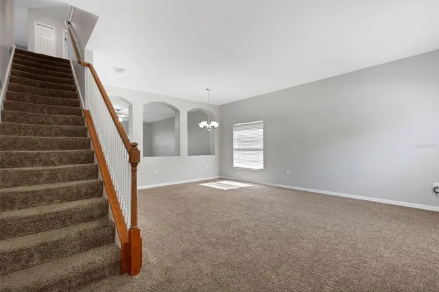 a view of an empty room with stairs and stairs
