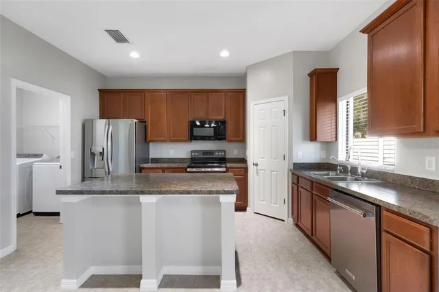 a kitchen with stainless steel appliances granite countertop a stove a sink a refrigerator and a granite counter tops
