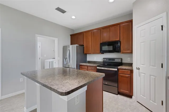 a kitchen with stainless steel appliances granite countertop a stove a refrigerator a oven a sink and dishwasher