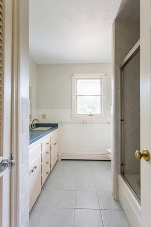 a bathroom with a granite countertop sink a mirror and a bathtub