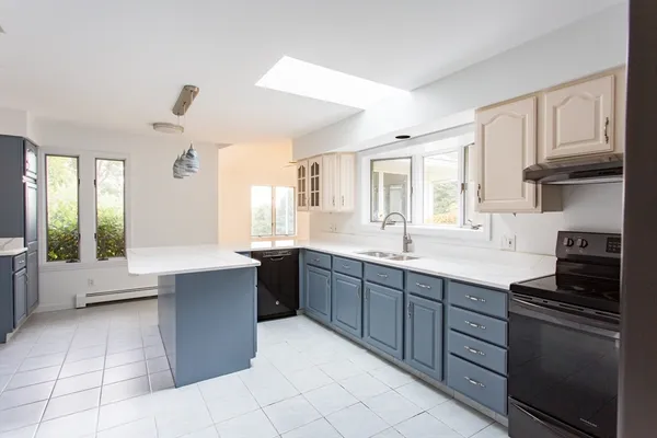a large kitchen with granite countertop a stove sink and cabinets