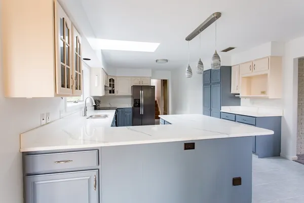 a kitchen with kitchen island a sink appliances and cabinets