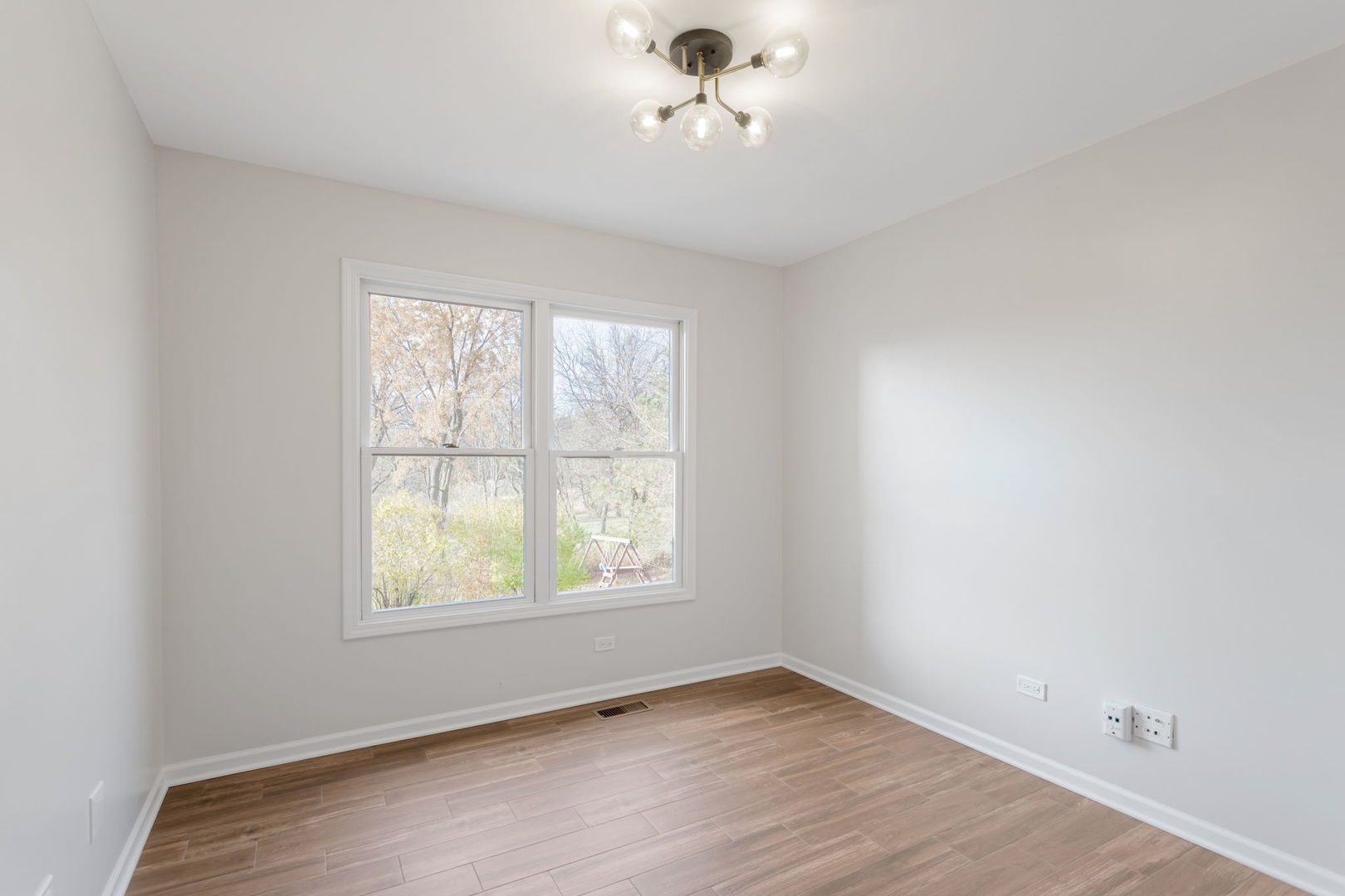 537 Arbor Lane Oswego, IL 60543 - Photo 16 of 33 an empty room with wooden floor ceiling fan and windows