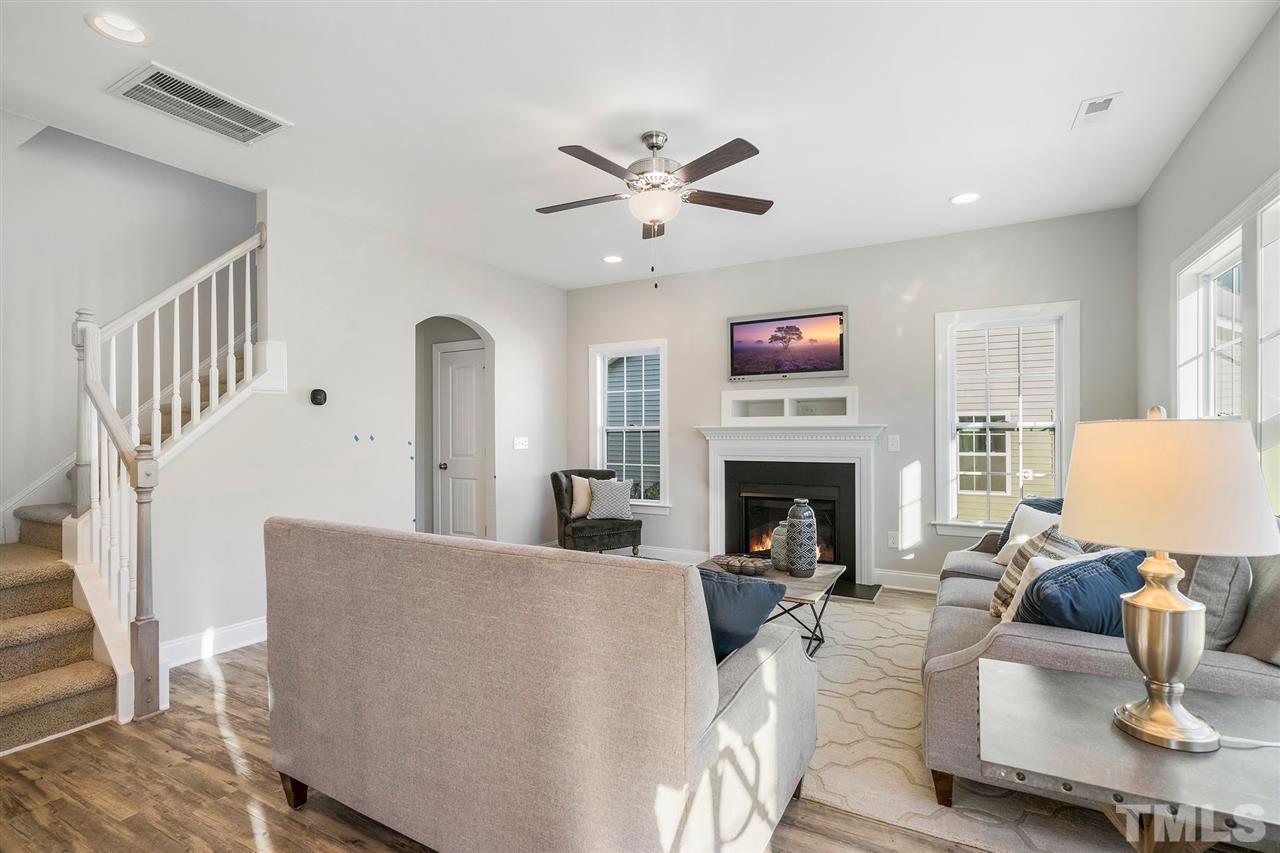 112 Edmer Lane Garner, NC 27529 - Photo 11 of 24 a living room with furniture a fireplace and a ceiling fan