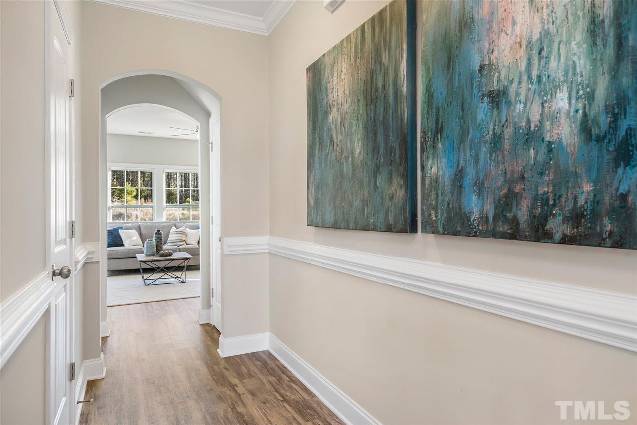 112 Edmer Lane Garner, NC 27529 - Photo 17 of 24 a hallway with a wooden floor and a table