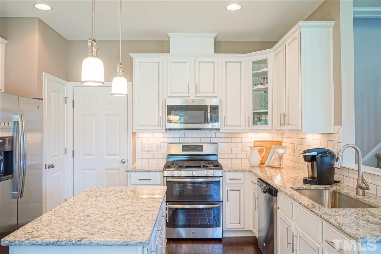 112 Edmer Lane Garner, NC 27529 - Photo 20 of 24 a kitchen with kitchen island granite countertop a stove and a wooden floors