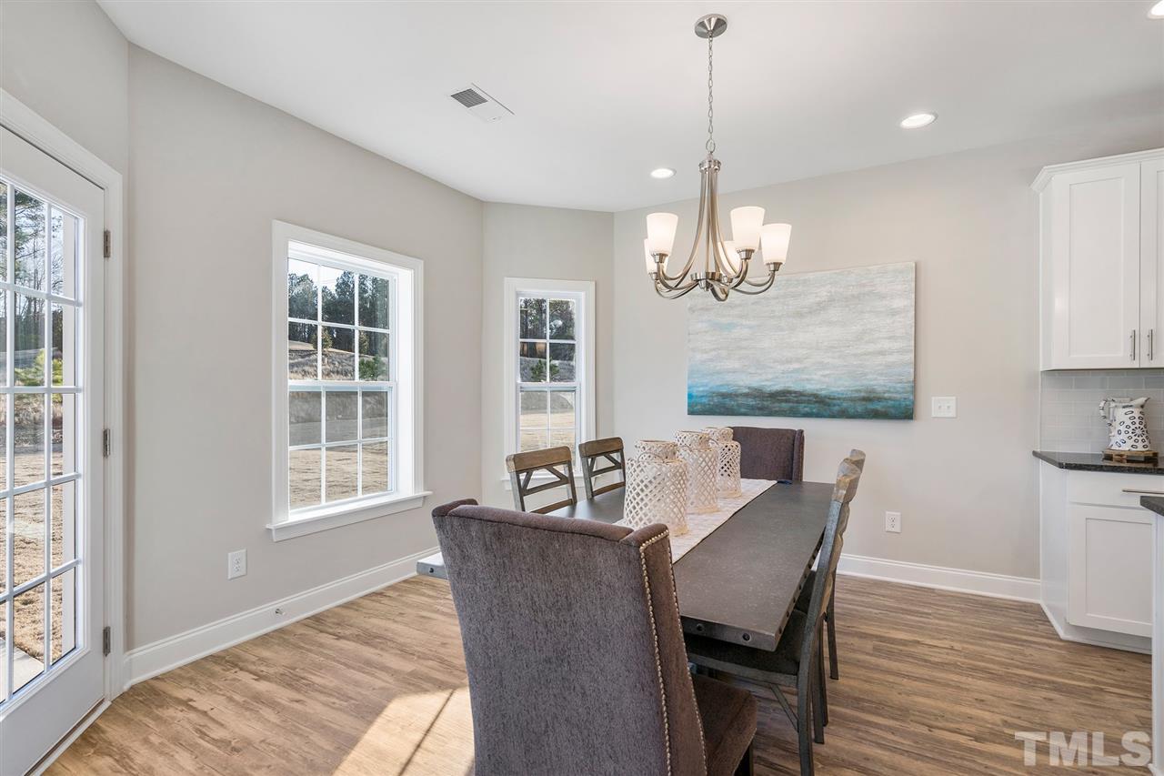 112 Edmer Lane Garner, NC 27529 - Photo 3 of 24 a view of a dining room with furniture wooden floor and chandelier