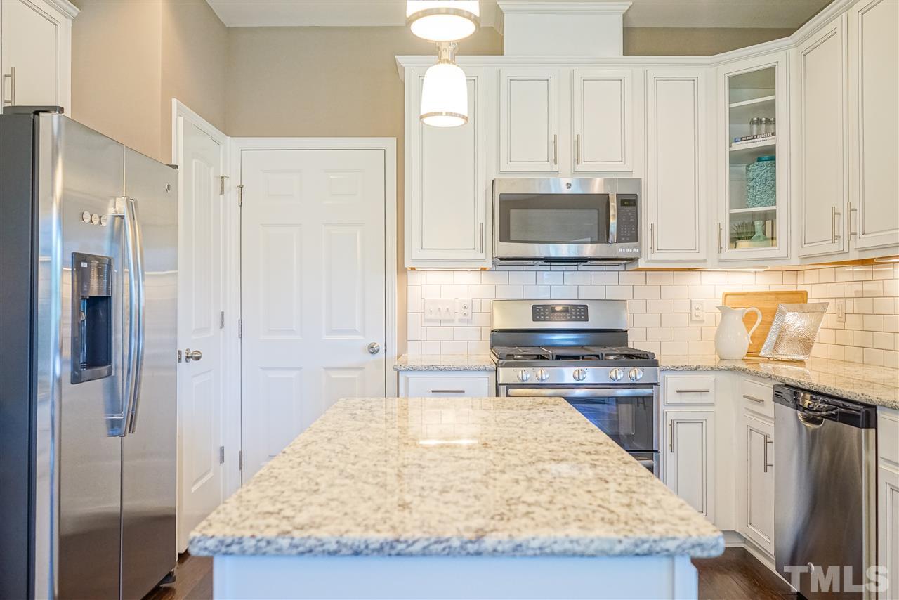 112 Edmer Lane Garner, NC 27529 - Photo 23 of 24 a kitchen with kitchen island granite countertop a sink stove and refrigerator