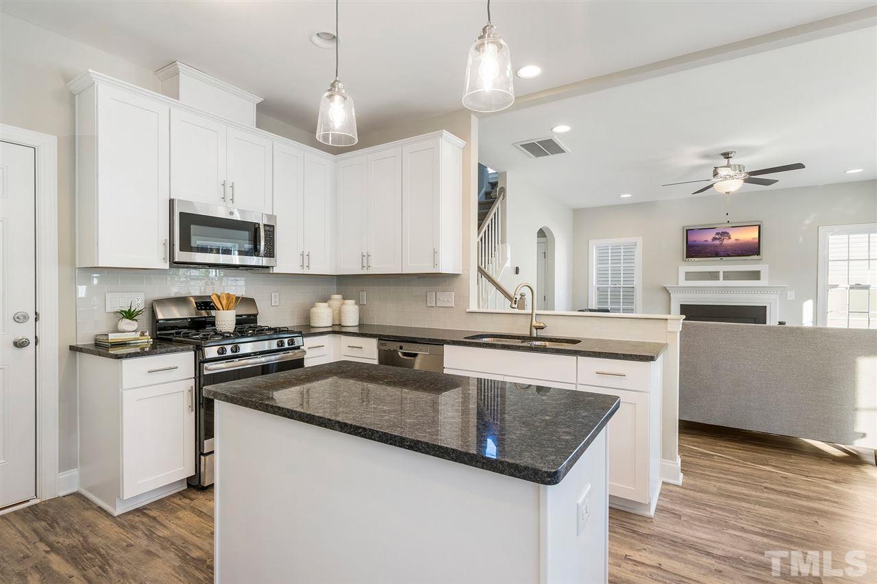 112 Edmer Lane Garner, NC 27529 - Photo 5 of 24 a kitchen with kitchen island granite countertop a sink a counter space appliances and cabinets