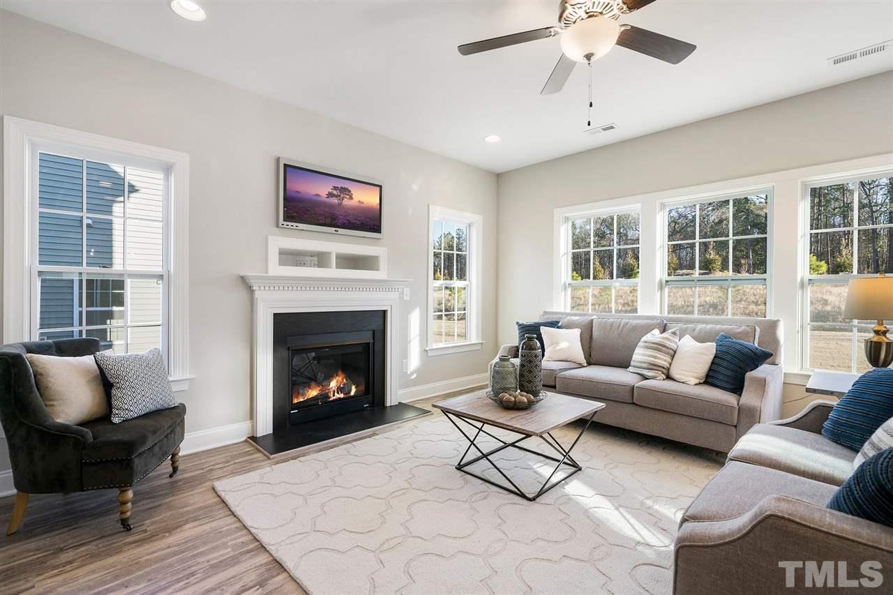 112 Edmer Lane Garner, NC 27529 - Photo 9 of 24 a living room with furniture a flat screen tv and a fireplace