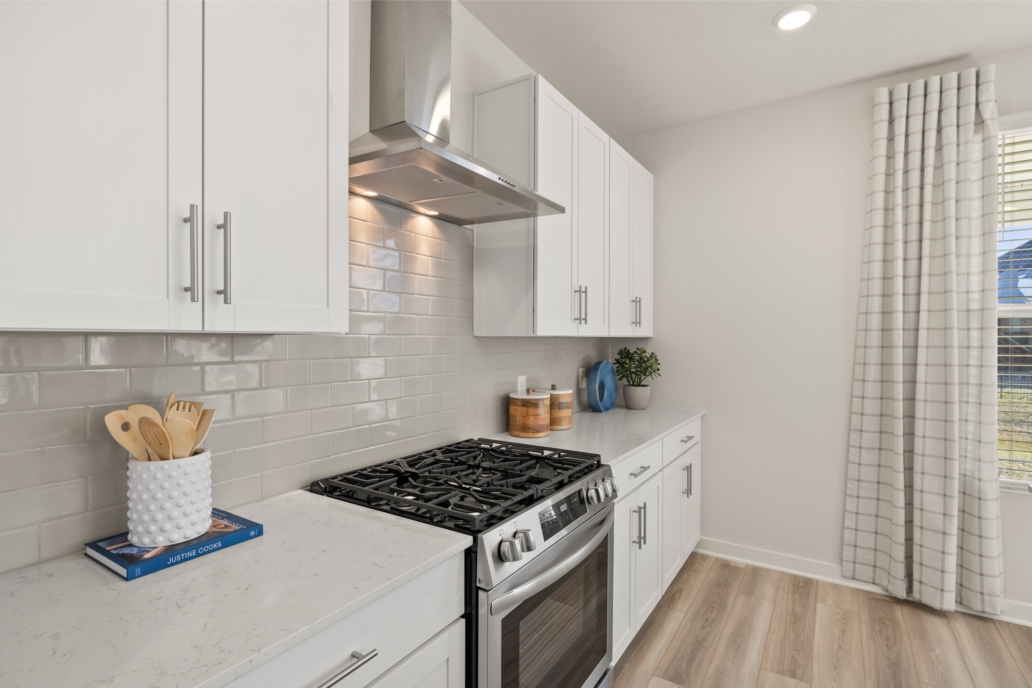 6364 North New Hope Road Hermitage, TN 37076 - Photo 13 of 56 a kitchen with granite countertop a stove and white cabinets with wooden floor
