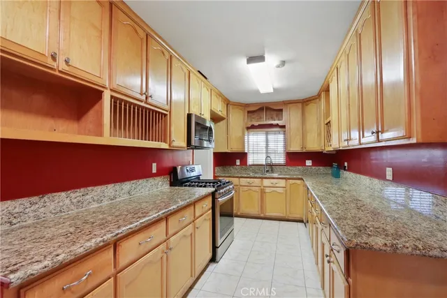a kitchen with stainless steel appliances granite countertop a sink and dishwasher a stove top oven with wooden floor