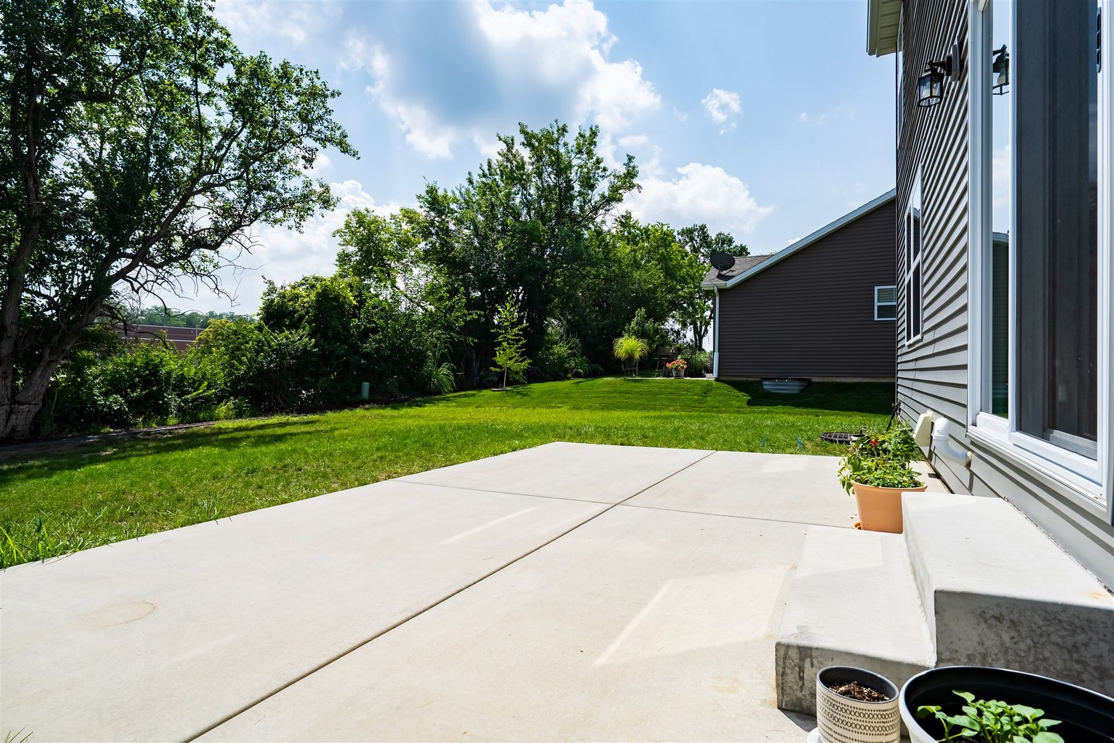 2512 Savanna Road Bloomington, IL 61705 - Photo 5 of 31 a view of a backyard with potted plants and large tree