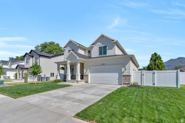 2664 West Maple Street Mapleton, UT 84664 - Photo 42 of 49 Modern suburban residence featuring light-colored siding, a covered entry porch with white columns, an attached two-car garage, a concrete driveway, and manicured lawns