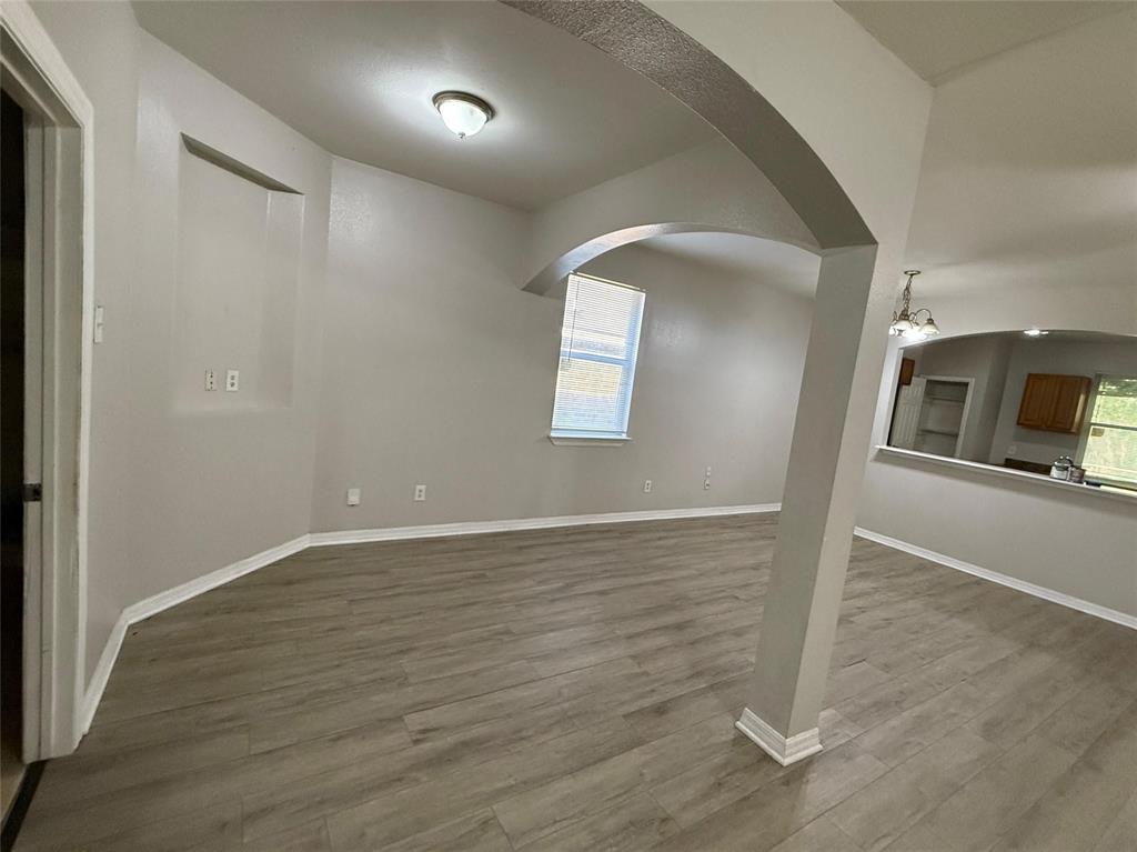 1823 Smoke Tree Lane Dallas, TX 75253 - Photo 6 of 13 an empty room with wooden floor and mirror
