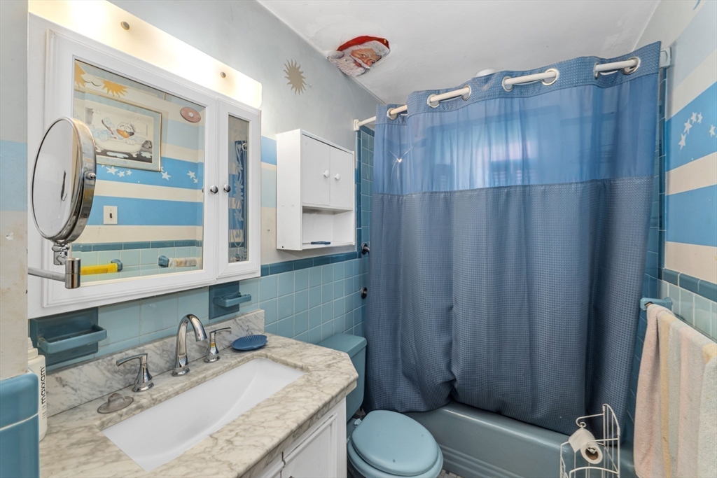 324 Central Avenue Dedham, MA 02026 - Photo 18 of 27 a bathroom with a granite countertop sink vanity mirror shower and toilet