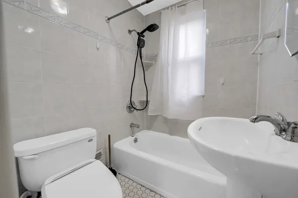 a white toilet sitting next to a bath tub