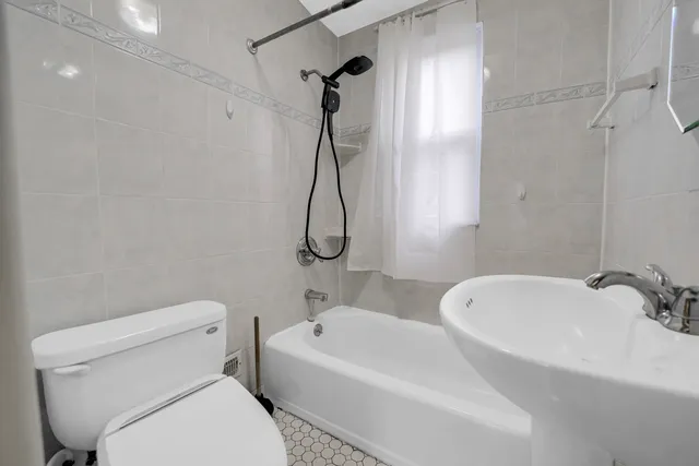 a white toilet sitting next to a bath tub