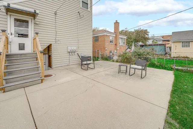 a view of a patio with a table and chairs and potted plants