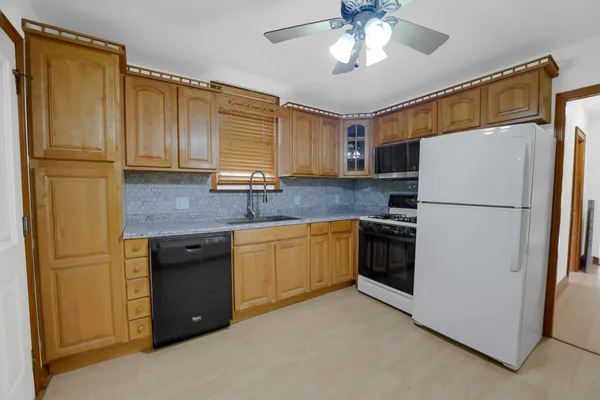 a kitchen with stainless steel appliances granite countertop a refrigerator a stove a sink and a refrigerator