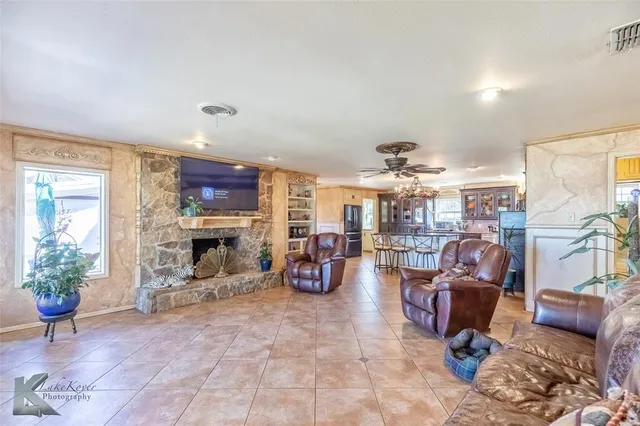 a living room with furniture a fireplace and a chandelier