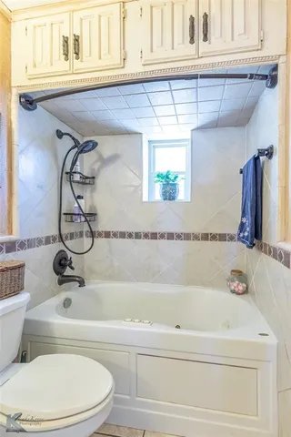 a bathroom with a granite countertop toilet a sink and a mirror