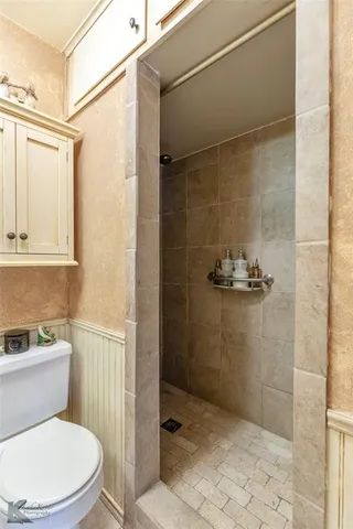 a bathroom with a granite countertop toilet sink and mirror