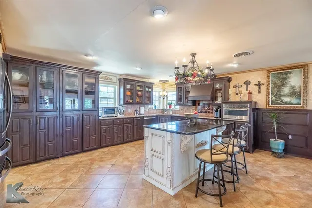 a kitchen with a dining table chairs stainless steel appliances and cabinets