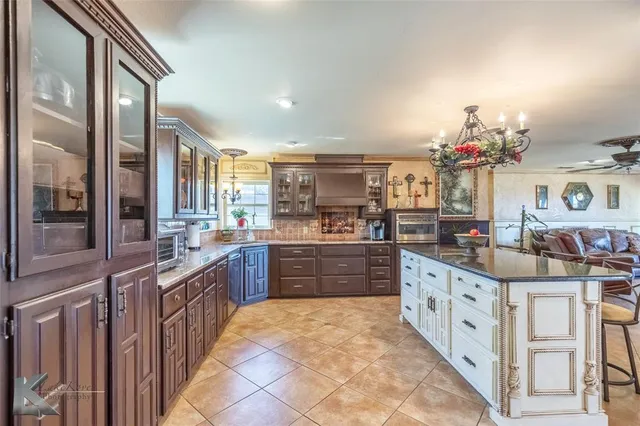 a kitchen with kitchen island granite countertop a sink counter top space and stainless steel appliances