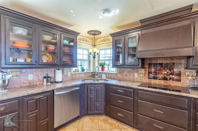 a kitchen with granite countertop wooden cabinets stainless steel appliances a sink and a window