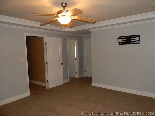 an empty room with a chandelier fan and closet