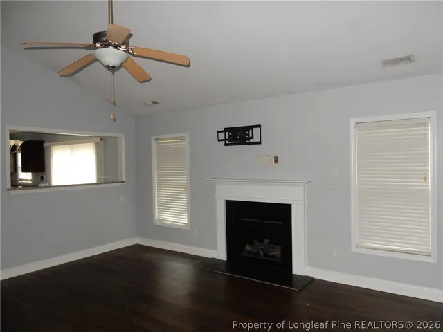 a living room with a fireplace and a ceiling fan