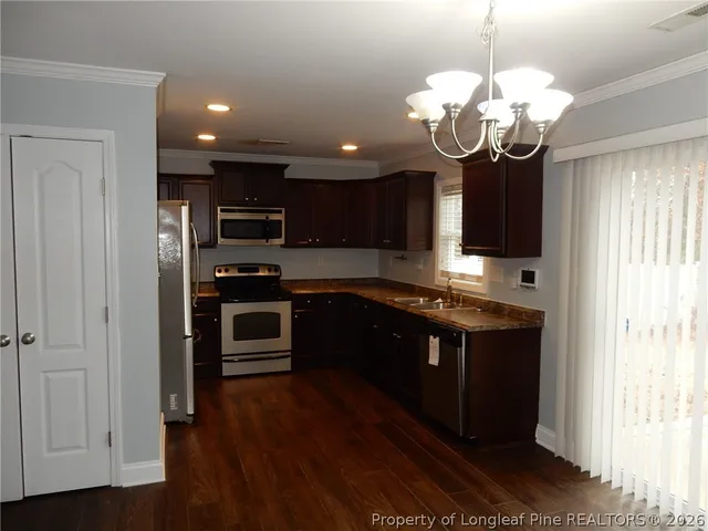 a large kitchen with stainless steel appliances granite countertop a stove and cabinets