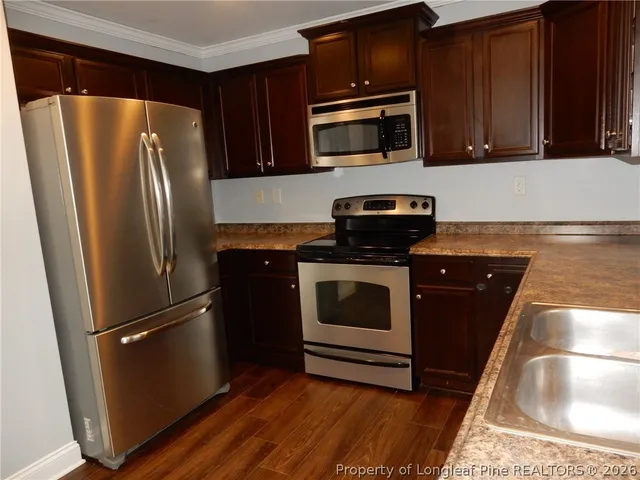 a kitchen with granite countertop a refrigerator stove and microwave
