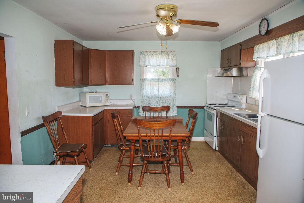 383 Elk Road Monroeville, NJ 08343 - Photo 3 of 25 a kitchen with stainless steel appliances granite countertop a dining table chairs refrigerator a sink and dishwasher