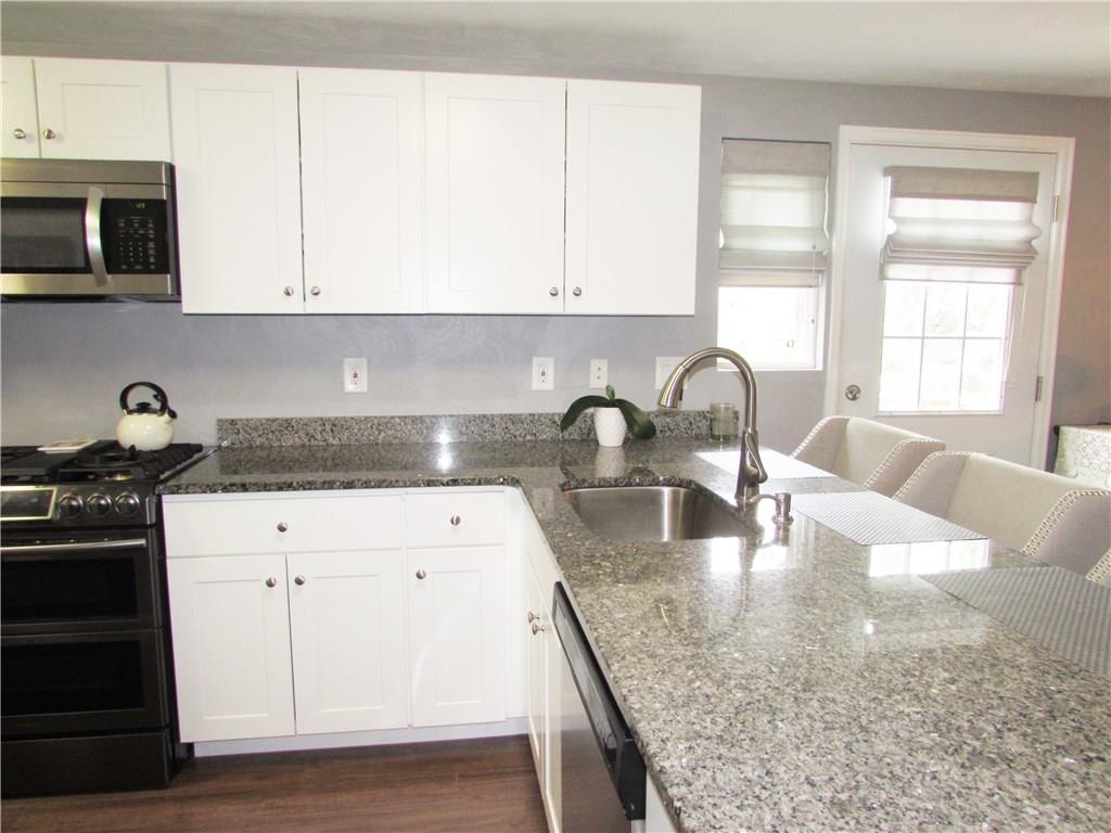 705 Bittersweet Road Monroeville, PA 15146 - Photo 12 of 25 The Remodeled Kitchen boasts Granite Countertops, SS Appliances, including Brand New Refrigerator, 5 Burner Gas Stove w/ Griddle, Microwave Oven, Dishwasher, Disposal, Breakfast Bar & 3 Chairs, Newer Sink, Cabinets & Lighting.