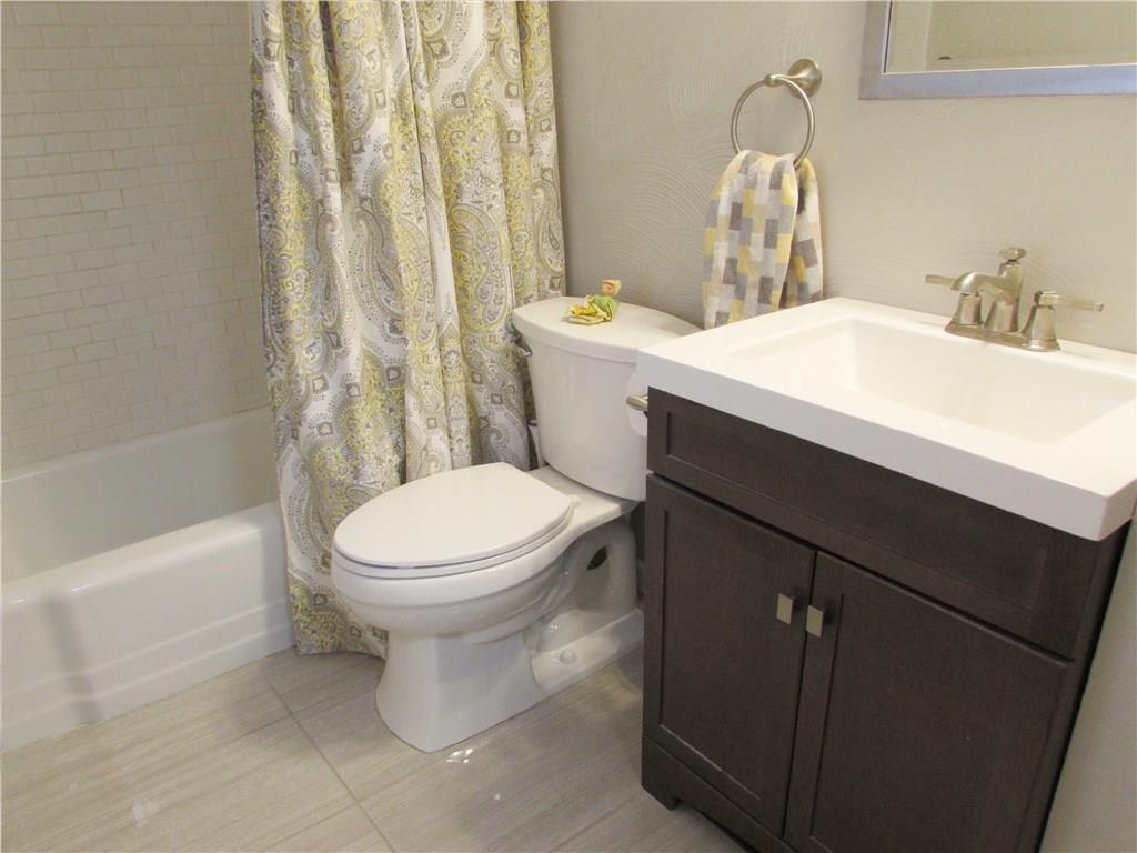 705 Bittersweet Road Monroeville, PA 15146 - Photo 20 of 25 A New Vanity, Sink, Toilet, Flooring, Lighting, & Subway Tile Tub Surround are found in the Main Bathroom.