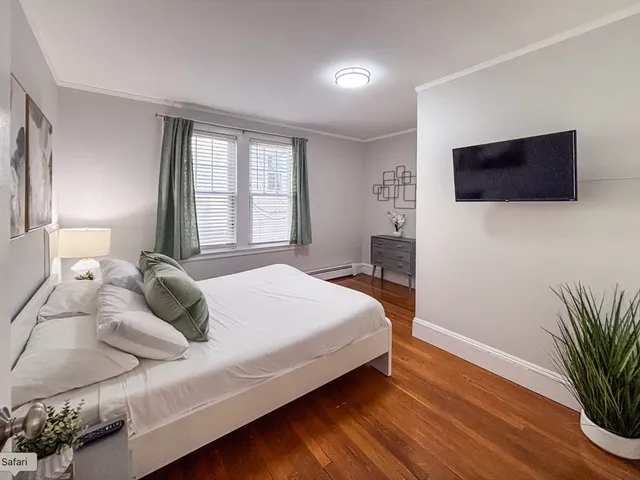 a bedroom with a large bed and a flat screen tv