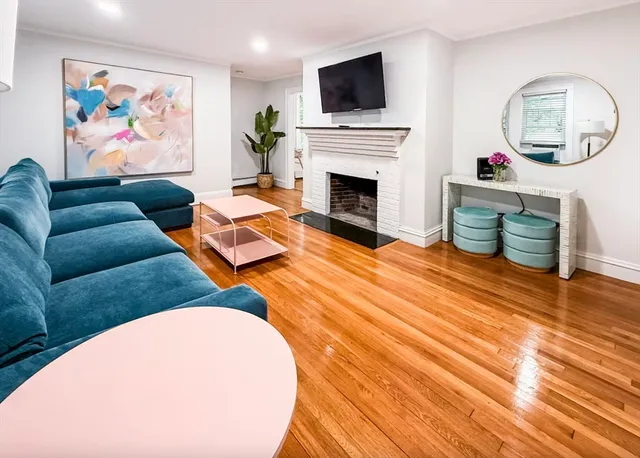 a living room with furniture a fireplace and a flat screen tv