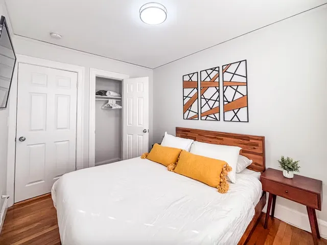 a bedroom with a bed and wooden floor