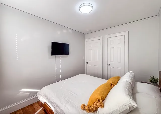 a bedroom with a bed and a flat screen tv