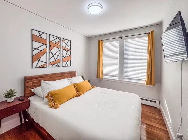 a bedroom with a bed and a large window