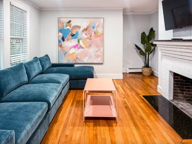 a living room with furniture a fireplace and a flat screen tv