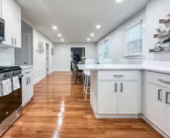 a large white kitchen with lots of counter space and stainless steel appliances