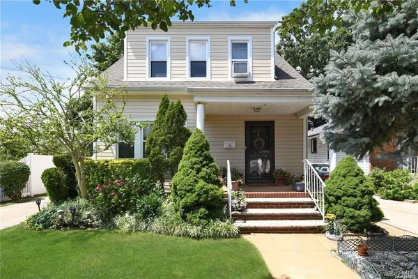 a front view of a house with a garden