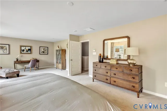 a spacious bedroom with a bed a couch and dresser